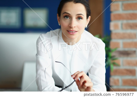 Portrait of young brunette woman in office Portrait of young brunette woman in office 76596977
