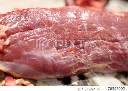Fresh piece of meat lies on table closeup 76597005
