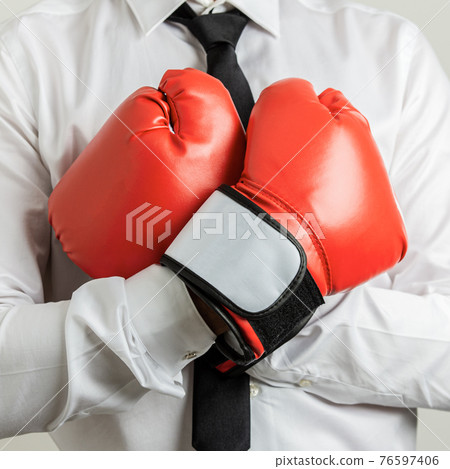 Businessman wearing red boxing gloves Businessman wearing red boxing gloves 76597406