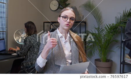 Female business company manager sitting at office desk reading resume, successful job interview Female business company manager sitting at office desk reading resume, successful job interview 76597617
