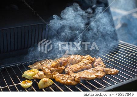 Whole Chicken Grilled On Hot Barbecue Charcoal Flaming BBQ grill with lovely meat smoke, concept of grilling Whole Chicken Grilled On Hot Barbecue Charcoal Flaming BBQ grill with lovely meat smoke, concept of grilling 76597849