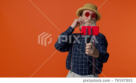 Senior grandfather traveler blogger in sunglasses, taking selfie on smartphone, video call online Senior grandfather traveler blogger in sunglasses, taking selfie on smartphone, video call online 76597891