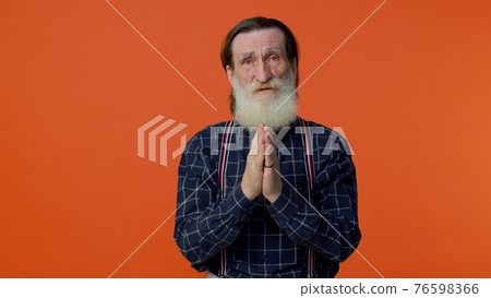 Mature old man praying to God making wish, asking with hopeful imploring expression, begging apology Mature old man praying to God making wish, asking with hopeful imploring expression, begging apology 76598366