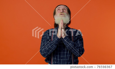 Mature old man praying to God making wish, asking with hopeful imploring expression, begging apology Mature old man praying to God making wish, asking with hopeful imploring expression, begging apology 76598367