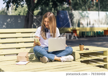 woman with laptop outdoors 76598408