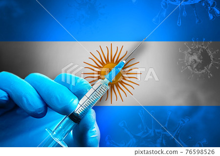 Argentina Covid-19 Vaccination Campaign. Hand in a blue rubber glove holds a syringe with covid-19 virus vaccine in front of Argentina flag Argentina Covid-19 Vaccination Campaign. Hand in a blue rubber glove holds a syringe with covid-19 virus vaccine in front of Argentina flag 76598526