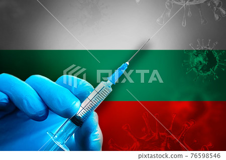 Bulgaria Covid-19 Vaccination Campaign. Hand in a blue rubber glove holds a syringe with covid-19 virus vaccine in front of Bulgaria flag 76598546