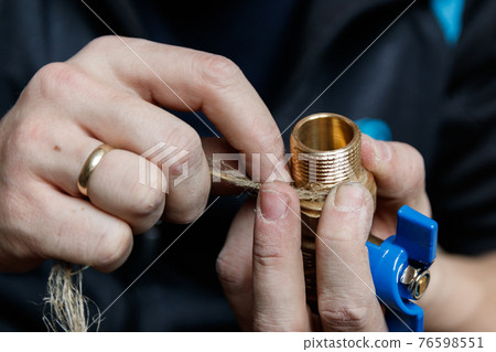 Cloce-up sealing pipe connections with linum flax. Professional plumber sealing threaded ends faucet with flax Cloce-up sealing pipe connections with linum flax. Professional plumber sealing threaded ends faucet with flax 76598551