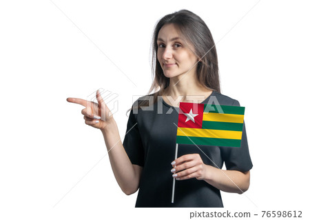Happy young white woman holding flag Togo and points to the left isolated on a white background Happy young white woman holding flag Togo and points to the left isolated on a white background 76598612