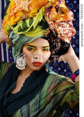 beauty bright woman with creative make up, many shawls on head like cubian, ethno look closeup 76599105