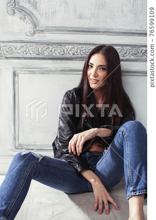 young brunette woman in leather jacket at vintage wall young brunette woman in leather jacket at vintage wall 76599109