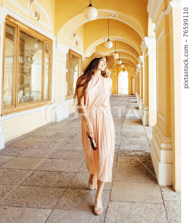 young pretty smiling woman in hat with bags on shopping at storefront, lifestyle real people concept 76599110