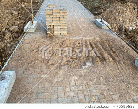 Pedestrian road repair. Disassembled paving slabs during road works 76599682