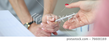 Above work table, hands and a pen on table are charts with business figures Above work table, hands and a pen on table are charts with business figures 76600169
