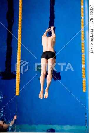male professional competitive swimmer in swimming pool 76600384