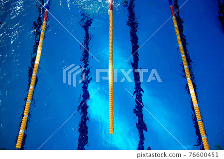 Calm water on empty swimming pool, dark lanes marks visible floor Calm water on empty swimming pool, dark lanes marks visible floor 76600451