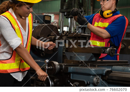 Group of skillful workers using machine equipment in factory workshop Group of skillful workers using machine equipment in factory workshop 76602070