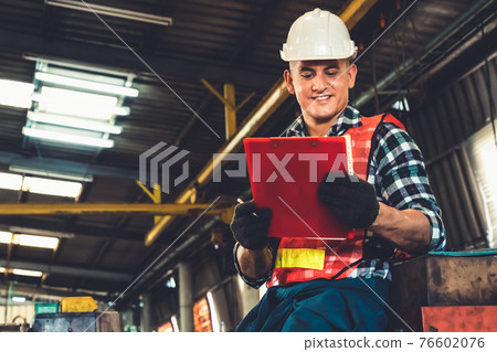 Manufacturing worker working with clipboard to do job procedure checklist . Manufacturing worker working with clipboard to do job procedure checklist . 76602076
