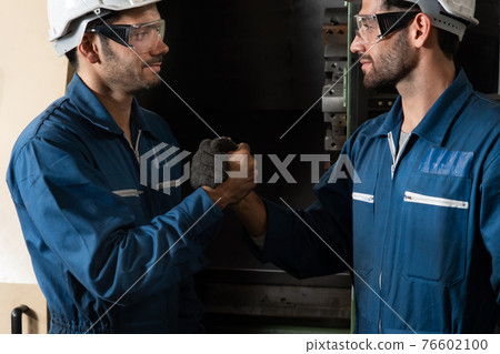 Two skillful factory engineer or worker showing teamwork and partnership . 76602100