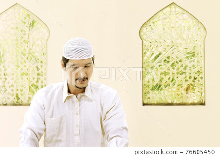Asian Muslim man sitting Asian Muslim man sitting 76605450