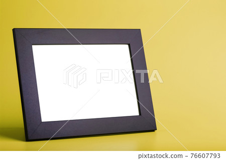 Black photo frame with free space on a yellow background. Black photo frame with free space on a yellow background. 76607793