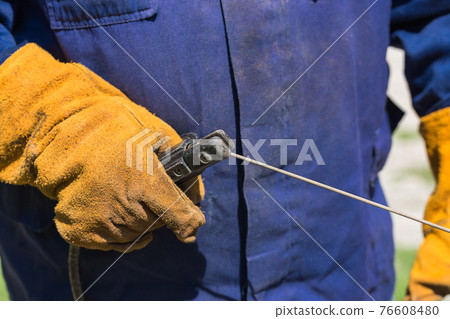 Profession welder, working specialty, equipment tool for welding metals electrode holder in the hands of a man at work, employment and labor 76608480