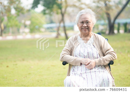 Asian senior or elderly old lady woman patient on wheelchair in park 76609431