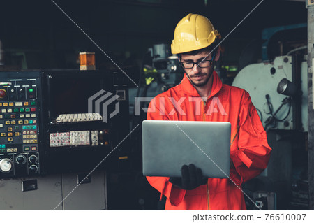 Skillful factory worker working with laptop computer to do procedure checklist . Skillful factory worker working with laptop computer to do procedure checklist . 76610007