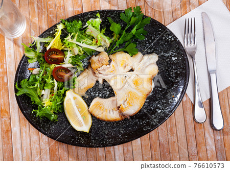 Dish of ocean fish tintorera with lemon and herbs. 76610573