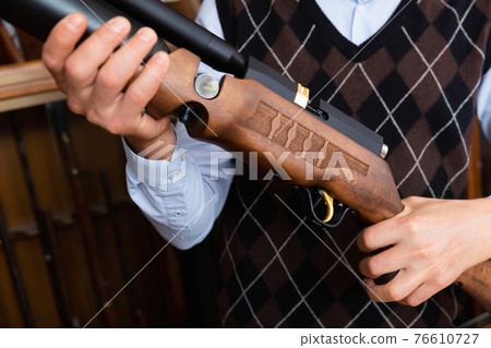 Closeup of sporting air PCP pump-action rifle in male hands 76610727