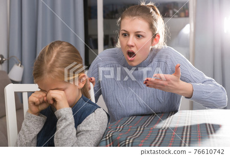 Dissatisfied mother scolds little girl 76610742