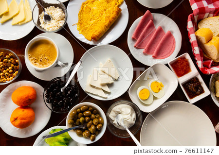 Turkish halal breakfast with cheese, sausages, eggs, vegetables, olives 76611147