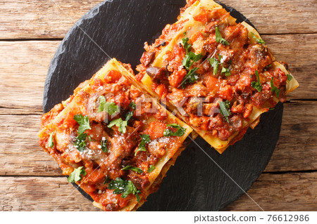 Pasta lasagna meat, chicken liver and vegetables vincisgrassi recipe close-up on a slate board. horizontal top view 76612986