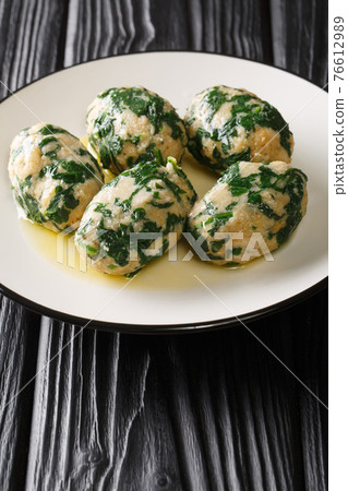 Spinach and Cheese Breadcrumb Dumplings Strangolapreti close-up in a plate. Vertical 76612989