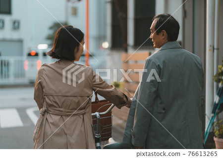 A couple in their 50s on their way home from work 76613265