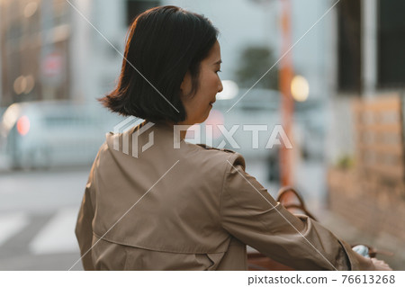 Woman in her 50s on the way home from work 76613268