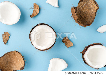Overhead shot of fresh cracked coconut on blue background. Flat lay. Close up 76613572