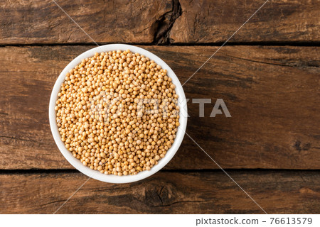 White mustard seeds in bowl on rustic wooden table. Top view 76613579