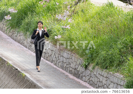 Business woman walking along the embankment (commuting / sales) 76613656