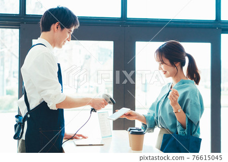 Young woman making a smartphone payment 76615045