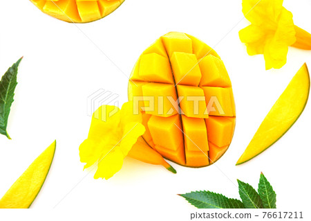 Ripe chopped mango on white with yellow flowers. Vegan beautiful dessert layout on white. Isolated image 76617211