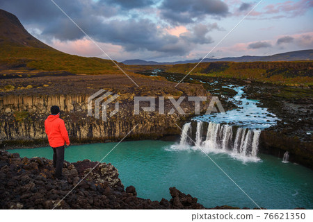 Hiker standing at the edge of the Thjofafoss waterfall in Iceland 76621350