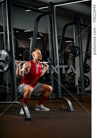 Closeup portrait of a muscular man workout with barbell at gym. Brutal bodybuilder athletic man with six pack, perfect abs, shoulders, biceps, triceps and chest 76622644