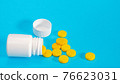 Yellow pills and plastic white bottle 76623031