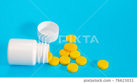Yellow pills and plastic white bottle Yellow pills and plastic white bottle 76623031
