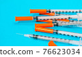 Insulin vial and syringe on blue background 76623034