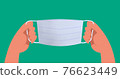 Hand holding a mask 76623449