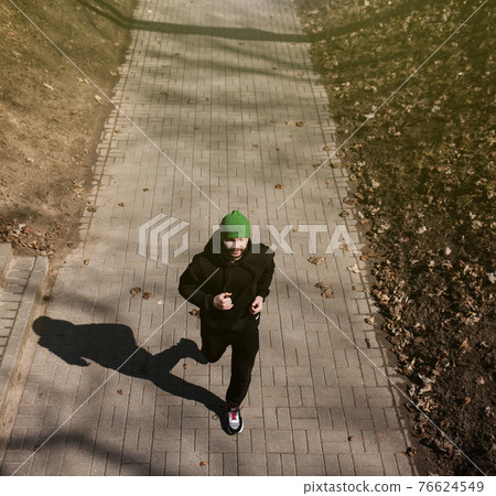 healthy man running in the park. 76624549