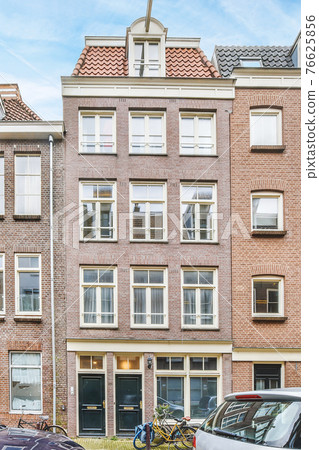 Facade of classic brick residential building in city 76625856
