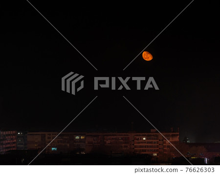 Rising of large orange moon over multi-storey residential buildings. Moon phases. Rising of large orange moon over multi-storey residential buildings. Moon phases. 76626303